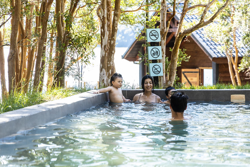 Familia disfrutando de una piscina termal al aire libre, una de las mejores opciones sobre qué hacer cerca de Puerto Varas en Termas de Cochamó.