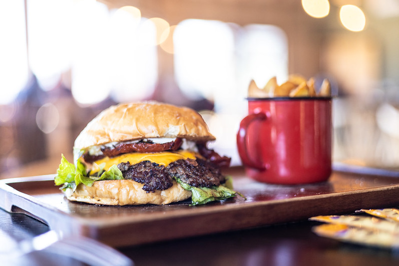 Hamburguesa y papas fritas en una bandeja de madera, parte del mejor panorama familiar en Cochamó.